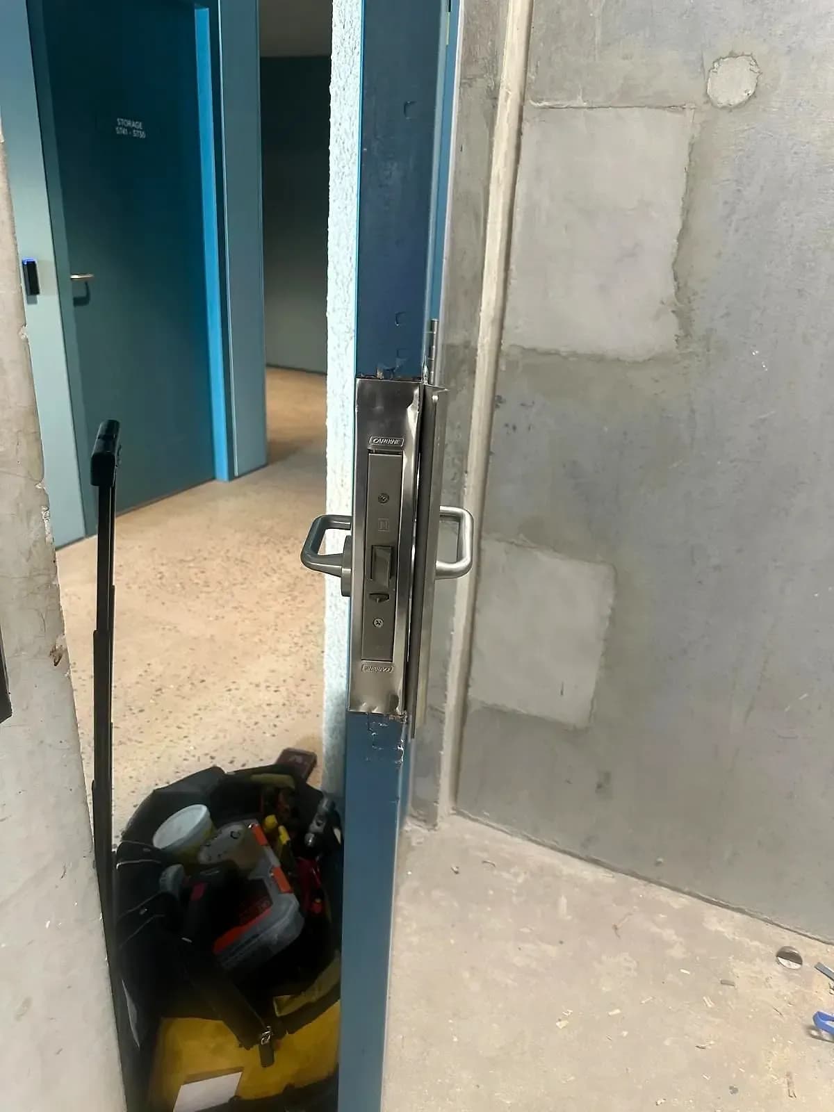 A Carbine mortice lock fitted in the edge of a blue service door, lever handles either side