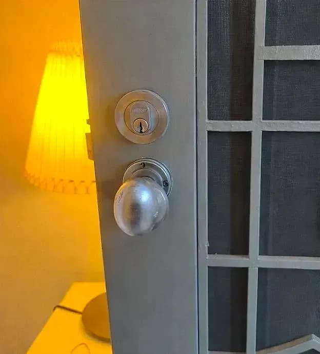 A front door with an old knob set and a separate deadbolt, before the smart lock